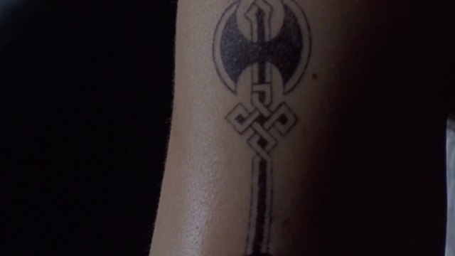 Close up of an arm with a labrys tattoo